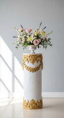 Delicate floral arrangement sits atop a decorative white marble column with ornate gold trim.