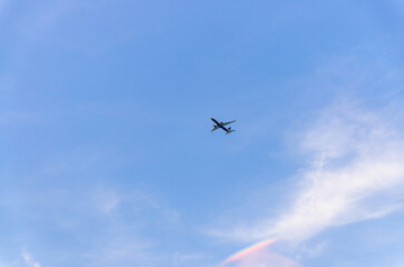 Airplane takes off into a blue sky with white clouds, Passenger plane aircraft flying across blue sky background, aircraft gaining altitude, view from below