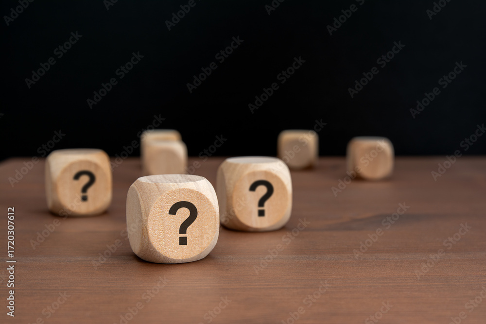 Poster three wooden blocks with question marks over a black background with copy space