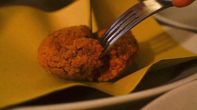 Eating Suppl&iacute;, a traditional Roman street food, rice croquettes filled with mozzarella