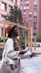 A woman uses a city map and geolocation on her smartphone to navigate the area while traveling.