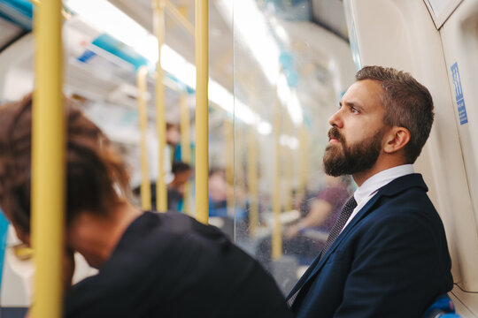 Side view of man sitting in subway train, travelling to work.