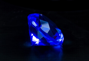 A polished blue gemstone on a black background