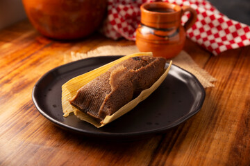 Chocolate Tamale. hispanic dish typical of Mexico and some Latin American countries. Corn dough wrapped in corn leaves. The tamales are steamed. Usually accompanied with atole, hot chocolate or coffee
