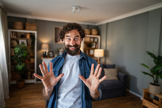 Excited man gesturing with both hands indoors
