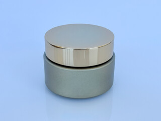 Cosmetic cream jar with golden lid on light background