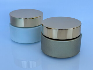 Elegant cosmetic cream jars with golden lids on light background