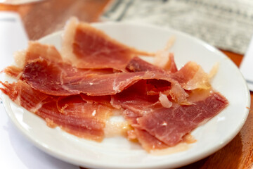 Slices of Teruel ham on a white plate served as an appetizer