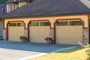 Garage door in luxury house with trees and nice landscape in Summer in Vancouver, Canada, North America. Day time on August 2025.