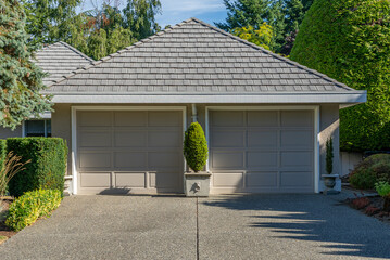 Garage door in luxury house with trees and nice landscape in Summer in Vancouver, Canada, North America. Day time on August 2025.