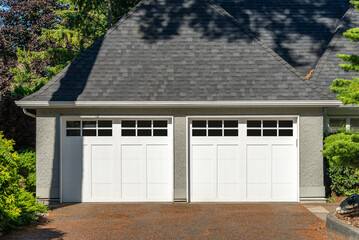 Garage door in luxury house with trees and nice landscape in Summer in Vancouver, Canada, North America. Day time on August 2025.