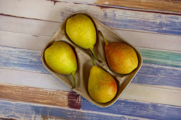 Four pears in a cardboard box.