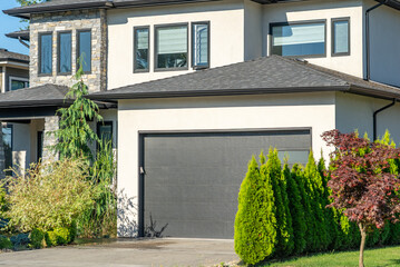 Garage door in luxury house with trees and nice landscape in Summer in Vancouver, Canada, North America. Day time on August 2025.