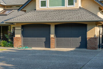 Garage door in luxury house with trees and nice landscape in Summer in Vancouver, Canada, North America. Day time on August 2025.
