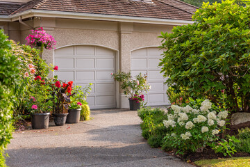 Garage door in luxury house with trees and nice landscape in Summer in Vancouver, Canada, North America. Day time on August 2025.