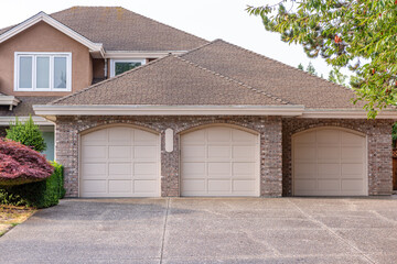 Garage door in luxury house with trees and nice landscape in Summer in Vancouver, Canada, North America. Day time on August 2025.