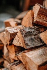 Close-up view of stacked firewood pieces, showcasing the varied textures and warm tones of the natural wood.