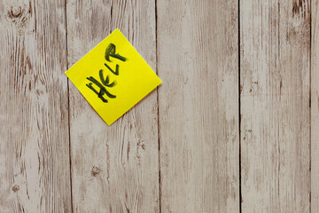 Yellow post-it note showing help message on wood background