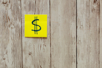 Dollar sign on sticky note symbolizing financial reminder