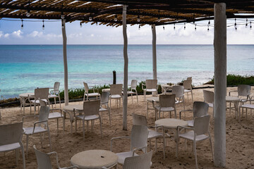 A beachside setting with empty chairs and tables awaiting visitors.