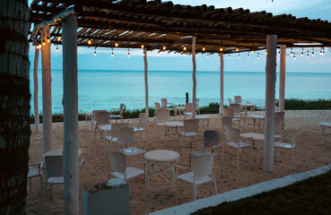 Beach viewSerene beachside restaurant with elegant setup at dusk by the ocean shore.