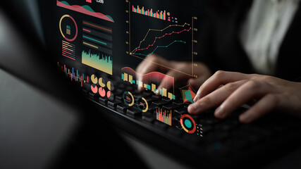 A professional data analyst engages with modern digital graphs and charts on a laptop, showcasing innovative data trends in a dimly lit office environment. Impute