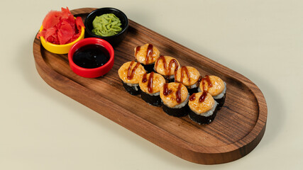 Sushi roll with soy sauce on wooden tray