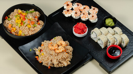 Sushi rolls and asian rice bowl on tray