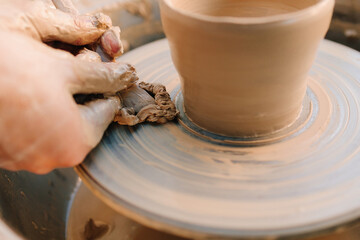 Clay pot is shaped on the wheel to create stable ceramic form. Clay pot forming on pottery wheel. Pottery shaping defines thickness, height, and symmetry before trimming and firing.