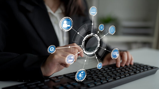 Professional woman typing on a keyboard in a modern office, surrounded by digital icons symbolizing technology, data analysis, and connectivity in the workplace. Crux - Powered by Adobe