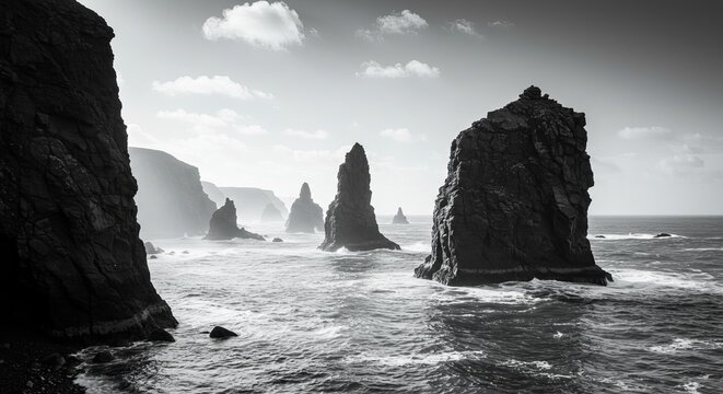 Dramatic sea stacks rise from wild ocean waves under a vast sky - Powered by Adobe