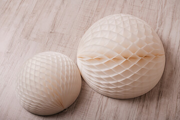 Decorative paper honeycomb balls on wooden floor.