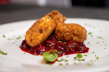 Crispy Fried Camembert Cheese with Sweet Cranberry Sauce on White Plate. Gourmet Appetizer Dish