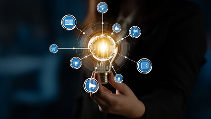 This image illustrates an innovative business concept featuring a light bulb surrounded by digital icons, symbolizing creativity and digital connection in a professional setting. Crux