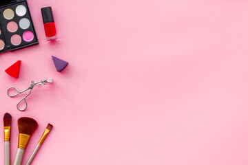 Flatlay of makeup cosmetics on pink background. Blusher, mascara and lipstick, top view
