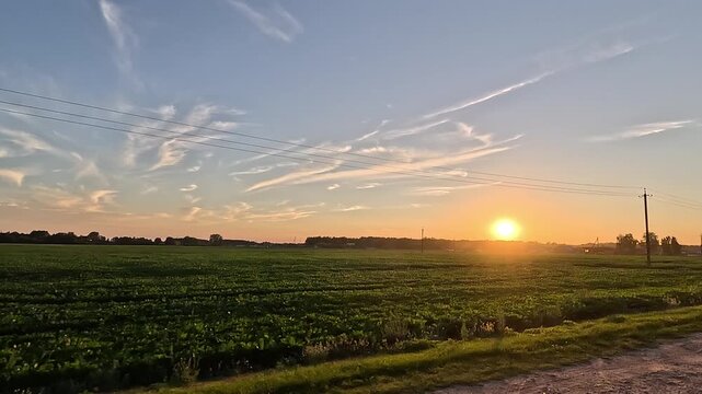Landscape, view of the road and the side of the road, driving against the backdrop of the sunset, sun rays and glare through trees