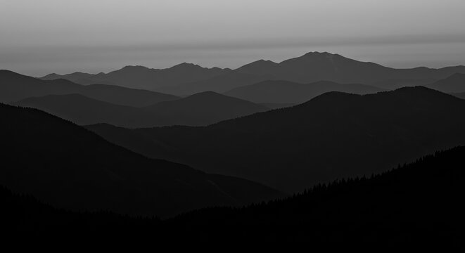 Dramatic dark mountain range silhouettes at dusk evoke a sense of awe and mystery