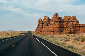 Stunning desert road framed by towering rock formations under a clear sky