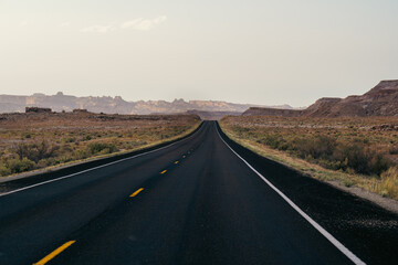 Endless Straight Road Through Desert Landscape Under Clear Blue Sky in Daylight