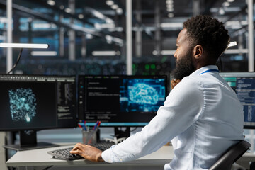 Server room worker using AI powered data visualization to perform demanding computing tasks. Admin in data center uses artificial intelligence predictive analytics for machine learning workloads