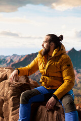 Determined climber pauses to admire the scenic view with mountains and a vast sky create a...