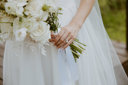 Close-up Bride Holding White Timeless and Romantic Bridal Bouquet with veil