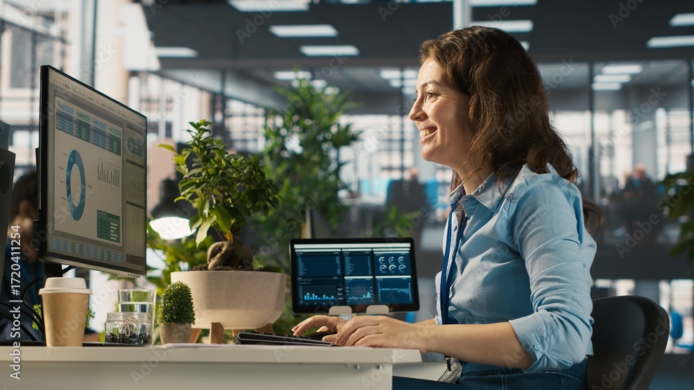 Poster cheerful employee at office desk having fun with coworkers while editing documents on computer. happ