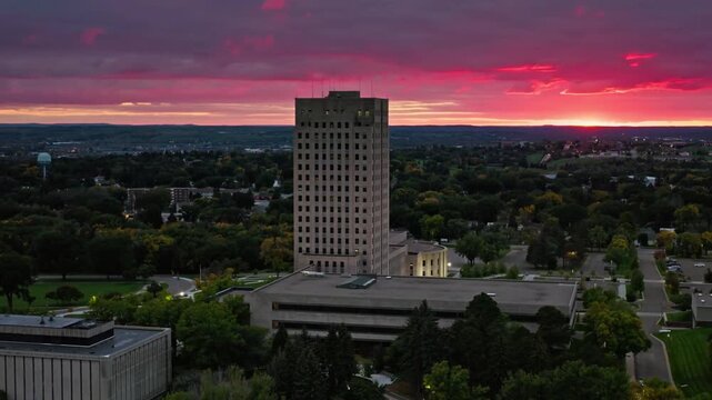 The north dakota state capitol stands tall against a dramatic sunset sky