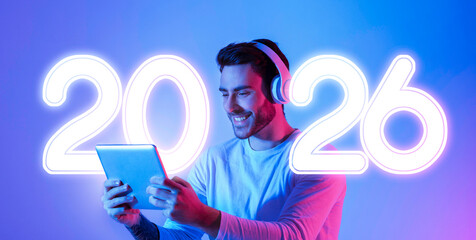 A smiling guy in headphones interacts with a tablet, immersed in music or gaming. The scene is illuminated by bright neon lights, adding a lively atmosphere to his activity.