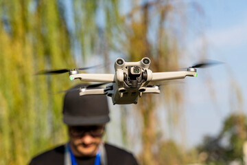 Modern drone in flight controlled by person outdoors