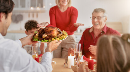 Young man serving traditional holiday turkey for big extended family, celebrating Thanksgiving or Christmas at home, enjoying festive meal with relatives, selective focus. Free space