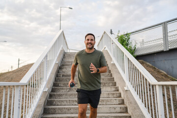 Man smiling while running down outdoor stairs