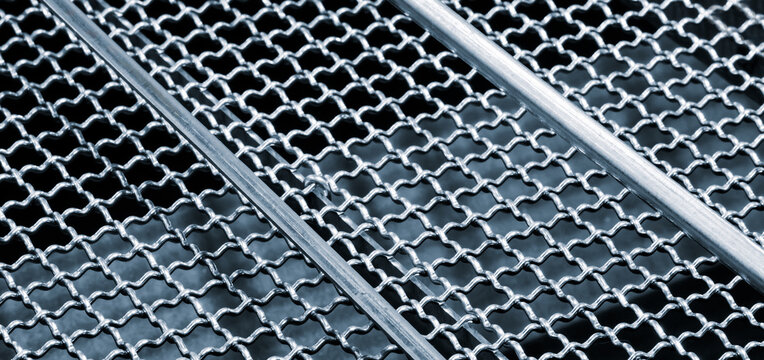 Close up of a metal mesh with a silver color. The mesh is made of metal and has a pattern