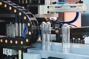 PVC plastic bottle production machine by extrusion and hot blowing technology industrial concept background.